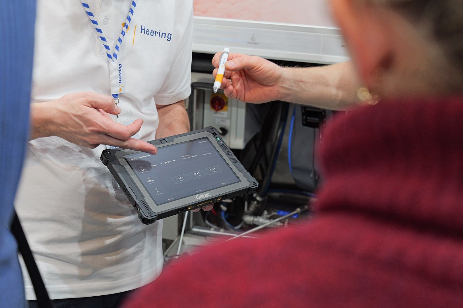 Chauffeur en technicus bekijken de temperatuurregeling op de Mission Control-tablet